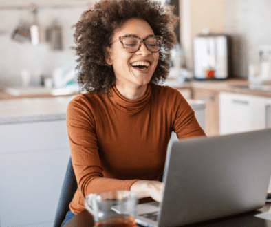 woman working from home on computer laughing