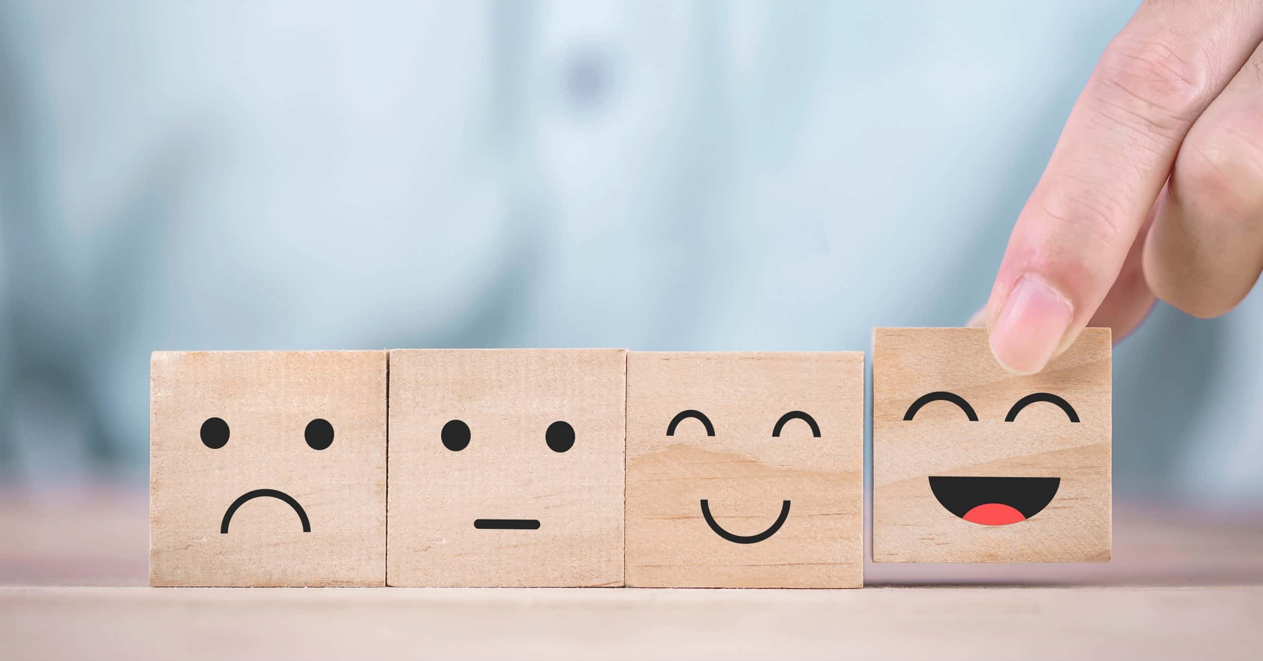 Image of four wooden blocks with various emotional faces