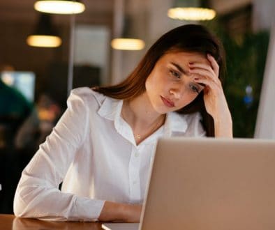 image of stressed woman at office in front of a laptop in an office