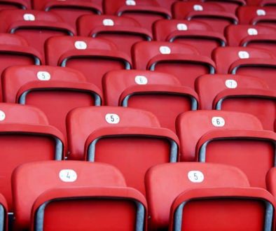 a photo of several rows of empty red seats at a stadium venue